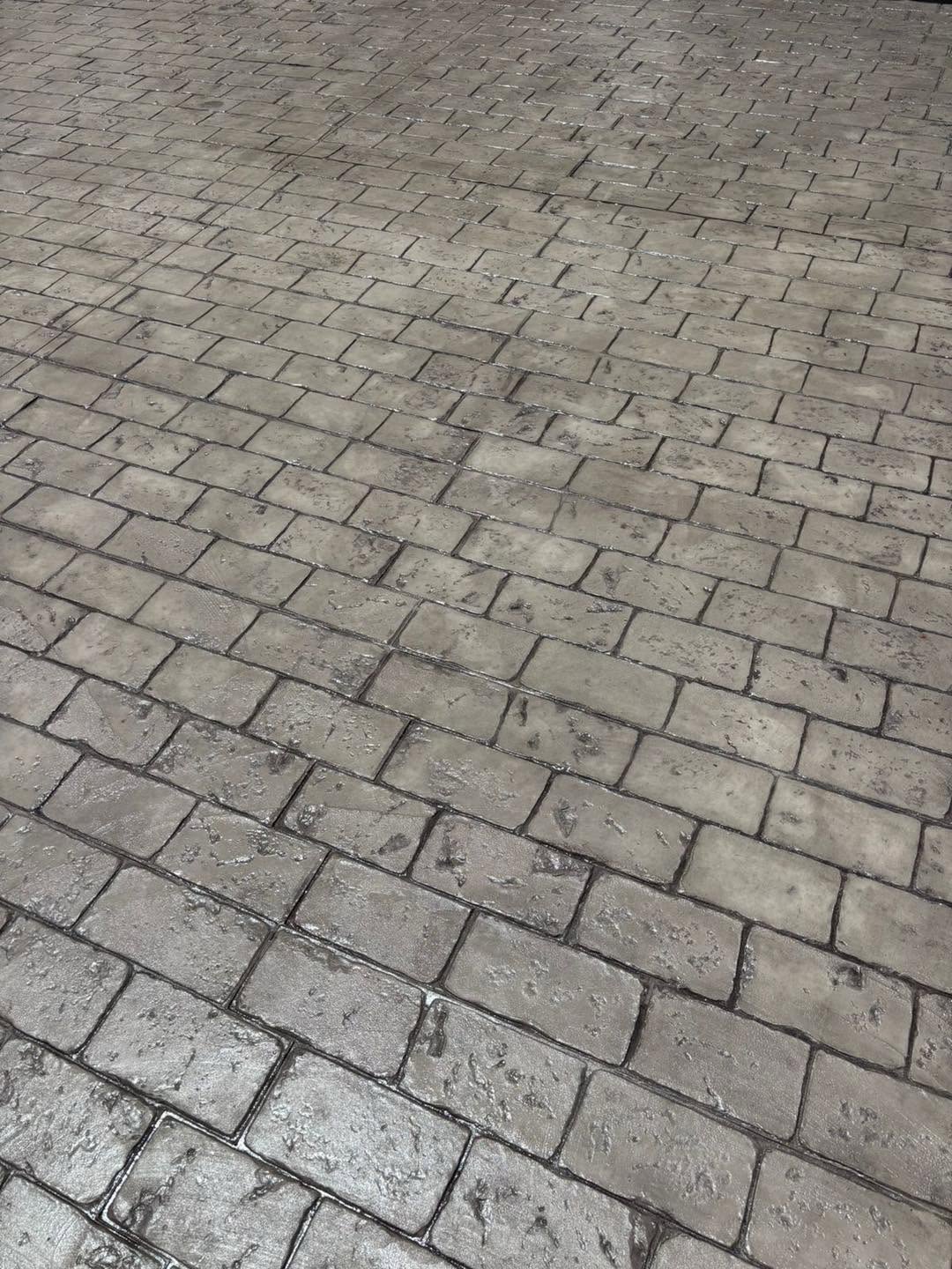 Piso de concreto gris con efecto adoquín, realizado por Acreto