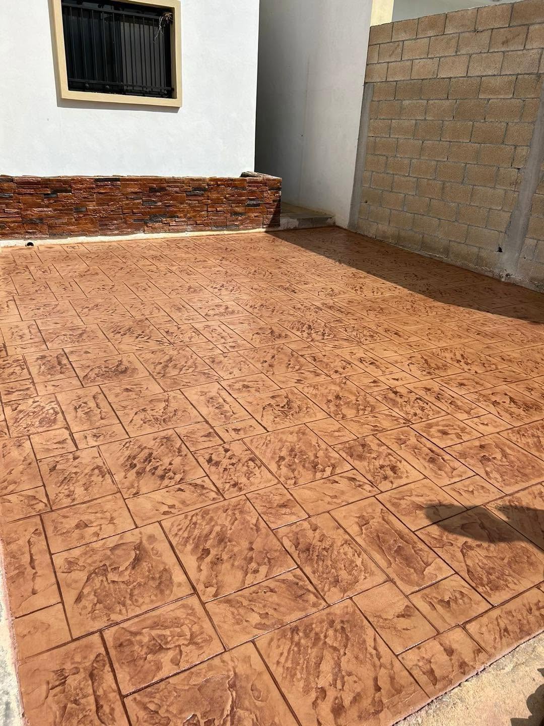Patio terracota junto a una fachada blanca con revestimiento de piedra